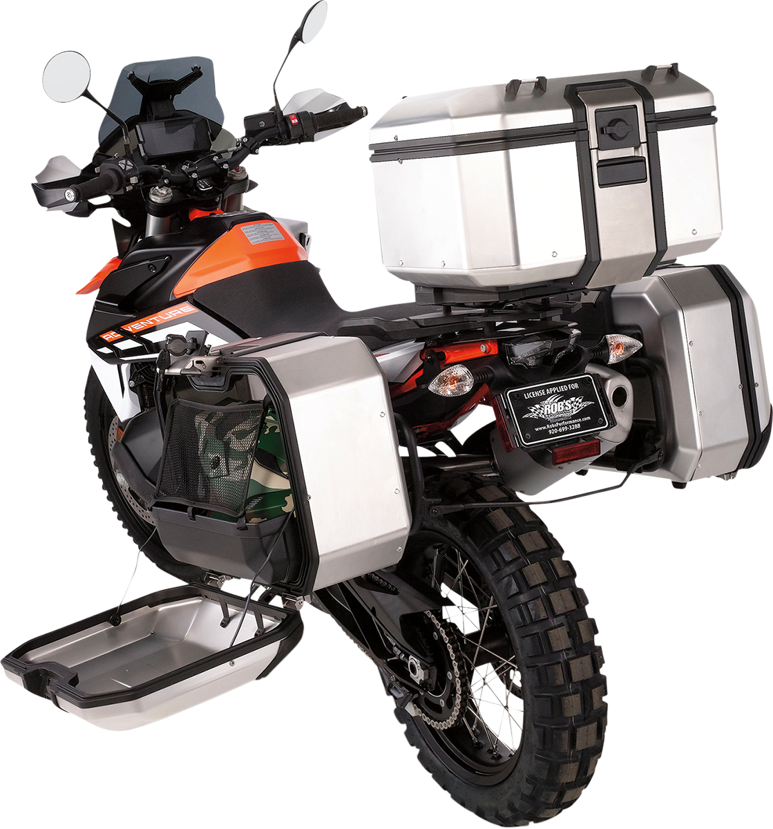 A rugged adventure motorcycle with off-road tires, black and orange body, and three large silver storage boxes—one on each side and one at the rear. The left side box is open, showing cargo space. The motorcycle has a tall windshield and visible handlebar