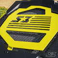 A close-up of the S3 Power Sports 2016+ Can-Am Outlander X Mr S3 Nation Radiator Guard shows a black and yellow grille with a stylized S3 and star logo cut into the yellow section, featuring an angular mesh design and a small star in the lower right corne