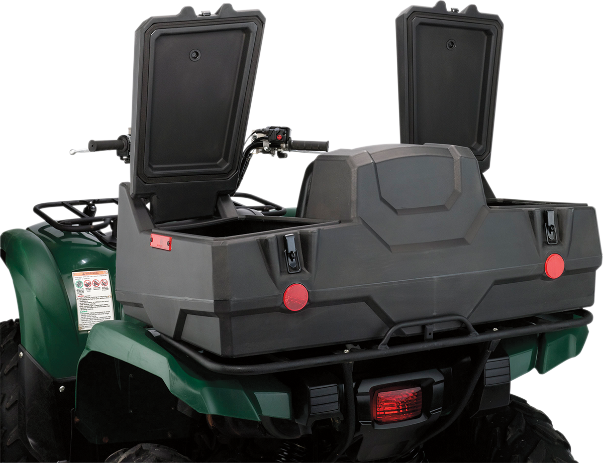 A green ATV with a large, black rear storage box attached. The storage box has two open compartments with raised lids and visible latches. Red reflectors are mounted on the box, and the ATV’s handlebars and part of the rear brake light are visible.