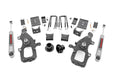 A Lowering Kit | 3 Inch FR | 5 Inch RR | Ford F-150 2WD (2004-2008) is displayed on a white background, featuring two large black spindles, silver shock absorbers, U-bolts, brackets, bushings, and assorted hardware.