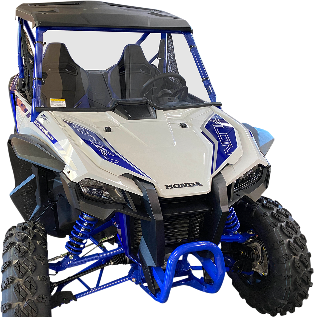 A blue and white Honda off-road utility vehicle with rugged tires, front grill, twin seats, roll cage, and suspension coils, viewed from a front angle against a plain white background.