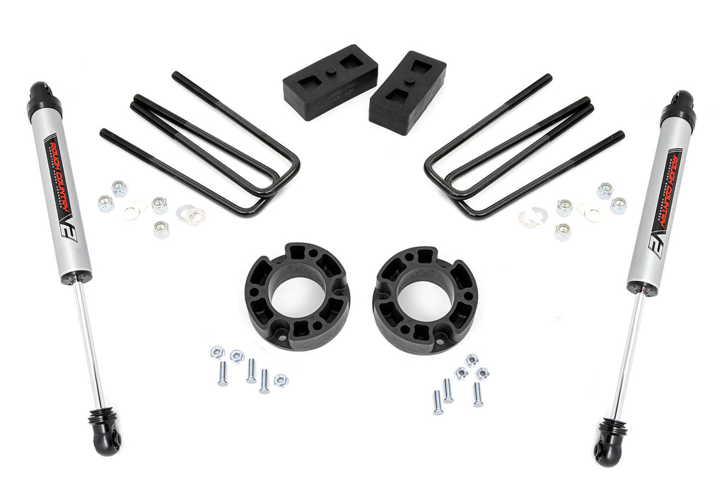 The 3.5 Inch Lift Kit | V2 for Chevy/GMC 1500 (07-13) includes two silver shock absorbers, four black U-bolts, two rectangular lift blocks, two round spacers, and assorted hardware—all displayed on a white background.