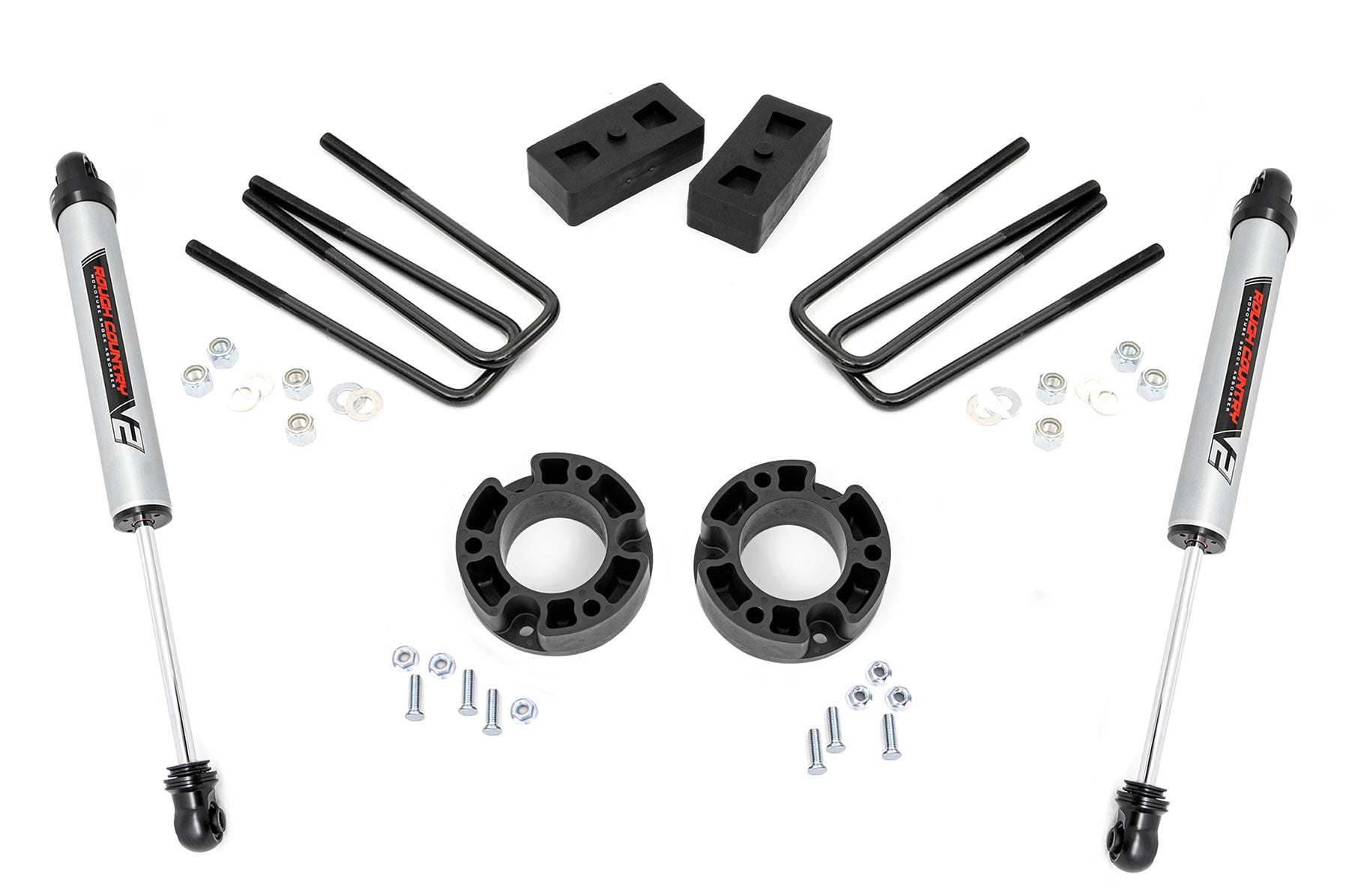 The 3.5 Inch Lift Kit | V2 for Chevy/GMC 1500 (07-13) includes two silver shock absorbers, four black U-bolts, two rectangular lift blocks, two round spacers, and assorted hardware—all displayed on a white background.