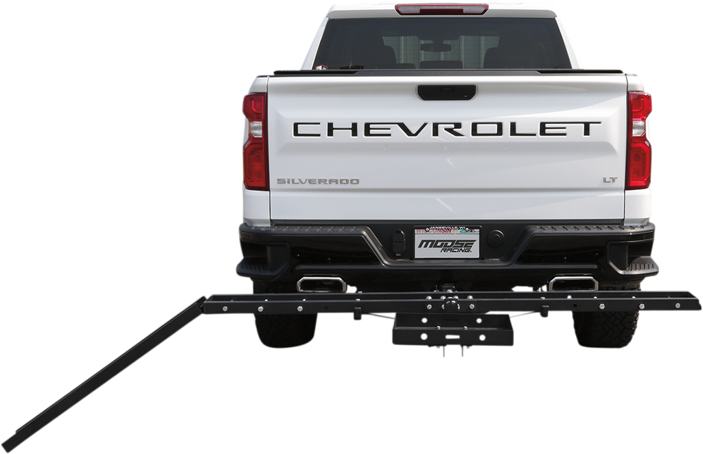 A white Chevrolet Silverado LT pickup truck is seen from behind. Attached to the trailer hitch is a black metal rack with an extended arm angled downward, likely for transporting items such as bikes or scooters. The vehicle is parked against a plain white