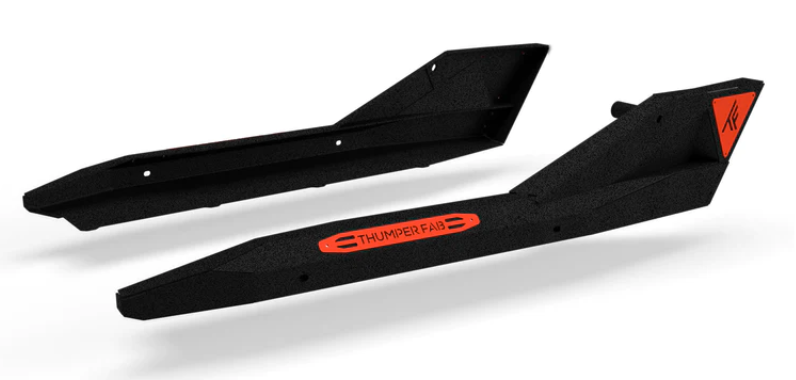 The 2017+ Can-Am Maverick X3 Rock Sliders (2 Seat) in black have a textured finish, bold orange accents, a THUMPER FAB logo in the center of one step, and a stylized TF logo on an orange triangle at the end of the other.