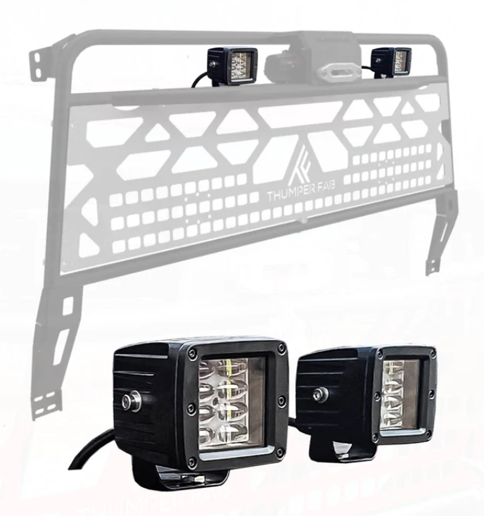 Black metal Thumper Fab headache rack with geometric cutouts, fitted with the Dual 3 LED Work Light Kit. Foreground shows a close-up of the two black LED lights, highlighting their mounting brackets and internal LEDs.
