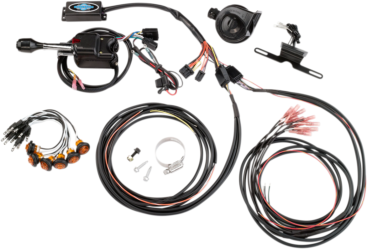 A motorcycle electronic wiring kit is laid out on a white surface. It includes various black cables, wiring harnesses, connectors, orange indicator lights, a black control box, clamps, screws, a relay, and other small electrical components.
