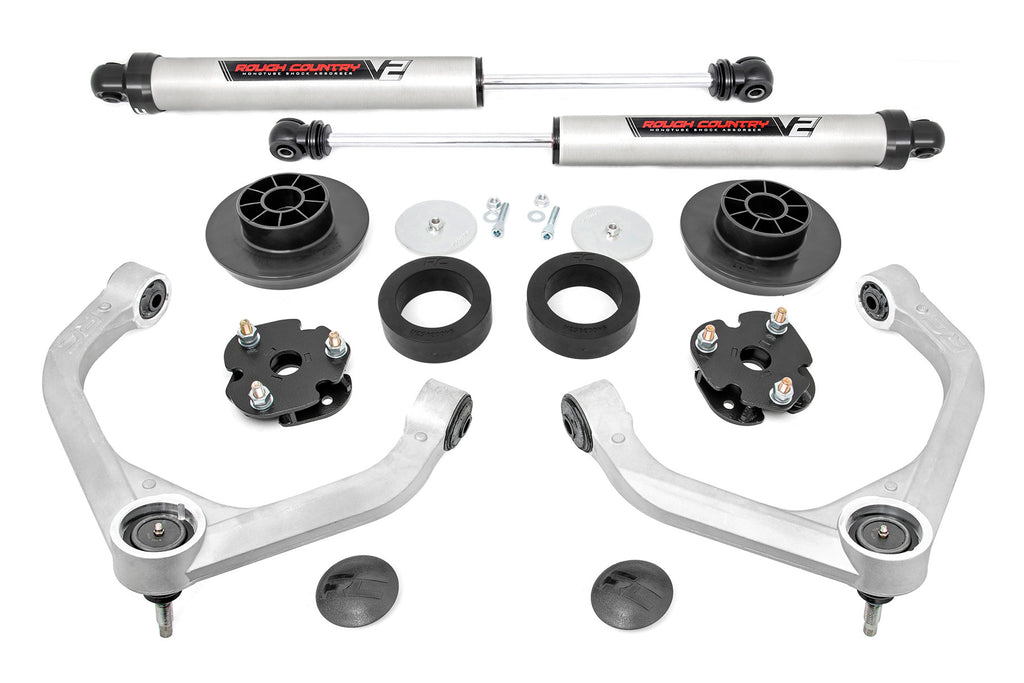The 3 Inch Lift Kit | V2 for Ram 1500 4WD (2012-2018 & Classic) is displayed on a white background with two silver shock absorbers, two control arms, coil and strut spacers, mounting hardware, and black plastic or rubber components.