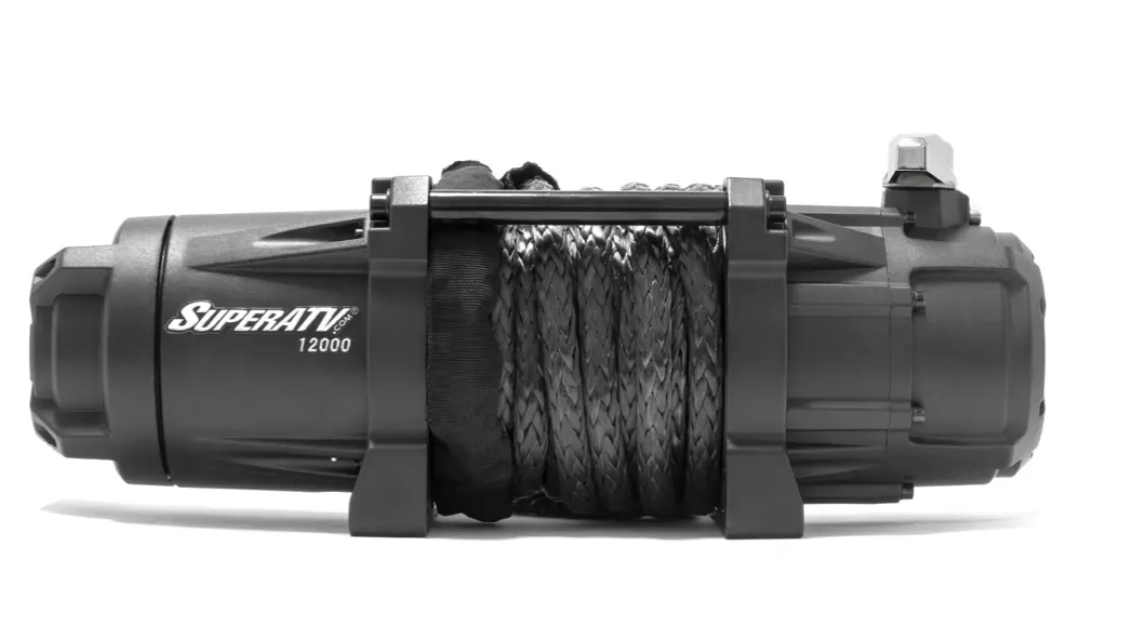 A black 12,000 Lb. UTV/ATV Winch with wireless remote and synthetic rope is shown on a white background, featuring sturdy mounting brackets and the SuperATV brand name with 12000 printed on the left side.