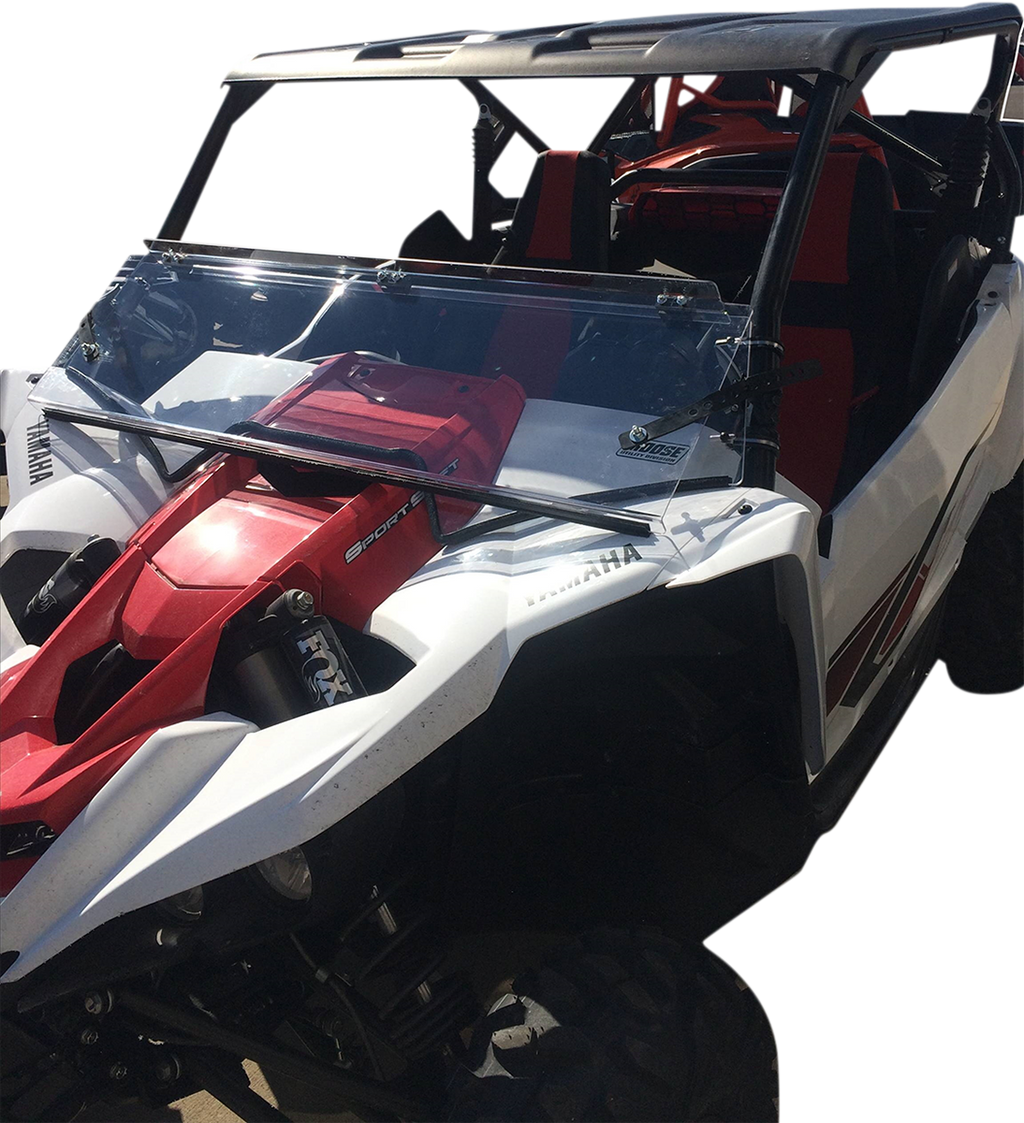 A white and red off-road utility vehicle with a clear windshield, black roof, and red seats. The Yamaha logo is visible on the side, and the vehicle is shown from the front left angle, highlighting its rugged design and suspension system.