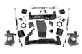The 5 Inch Lift Kit (Alum/Stamp Steel, V2) for Chevy/GMC 1500 (14-18) is displayed on a white background, featuring black or metallic gray brackets, shock absorbers, spindles, U-bolts, skid plates, hardware, and spacers arranged neatly.