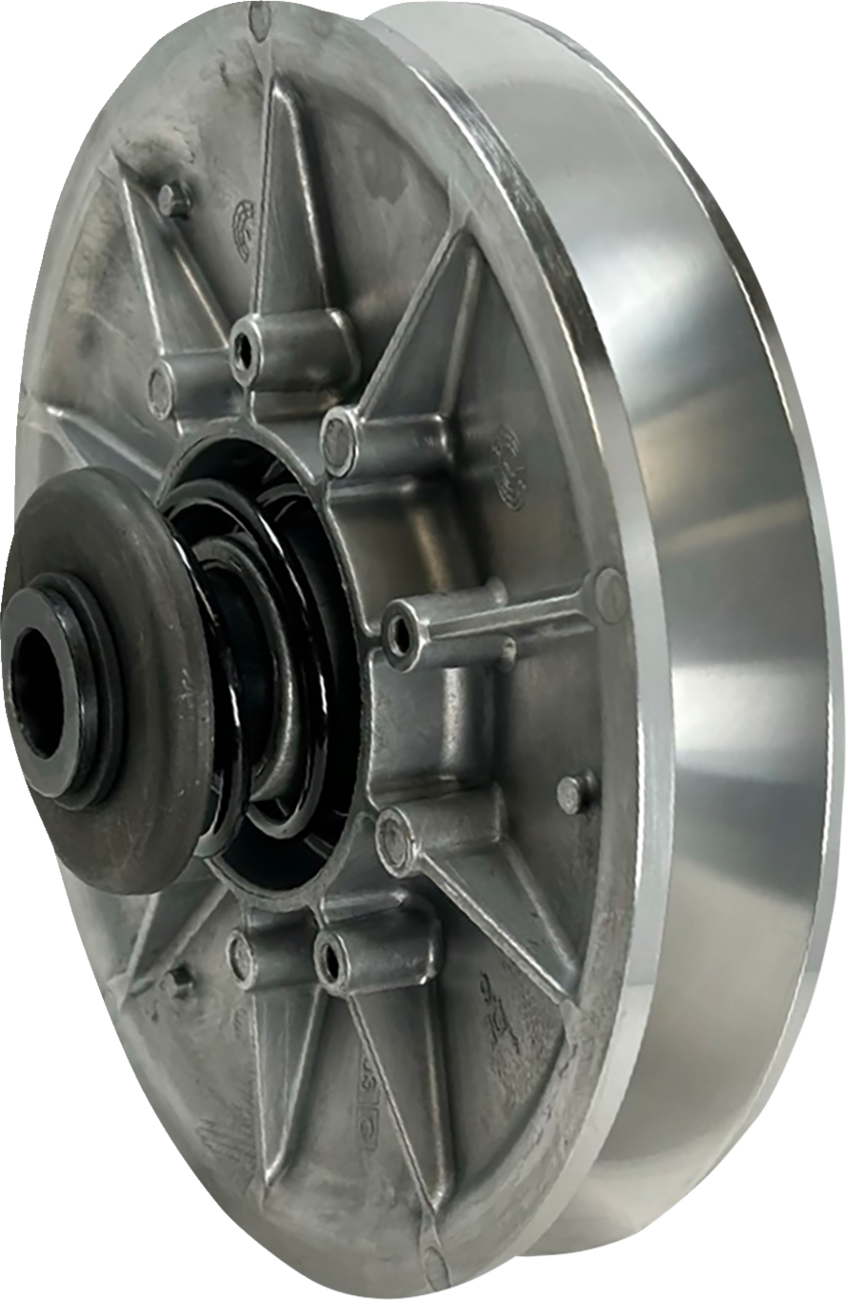 A close-up view of a metallic machine part, likely a pulley or clutch component, featuring a circular, ribbed design with a central hub and a spring mechanism, made of shiny silver metal with visible bolts and structural spokes.