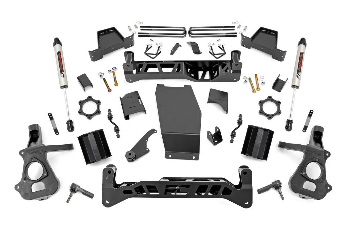 The 7 Inch Lift Kit | Cast Steel | V2 for Chevy/GMC 1500 (14-18) is displayed on a white background, featuring black metal brackets, shocks, spacers, knuckles, skid plate, bolts, nuts, washers, and organized installation hardware.