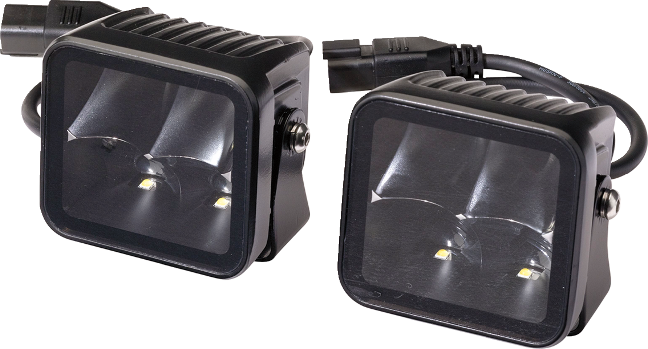 Two black, square-shaped LED work lights with clear lenses, mounted in metal housings. Each light contains two LED bulbs and reflective interiors. Power cables with connectors extend from the back of the lights, designed for off-road or automotive use.