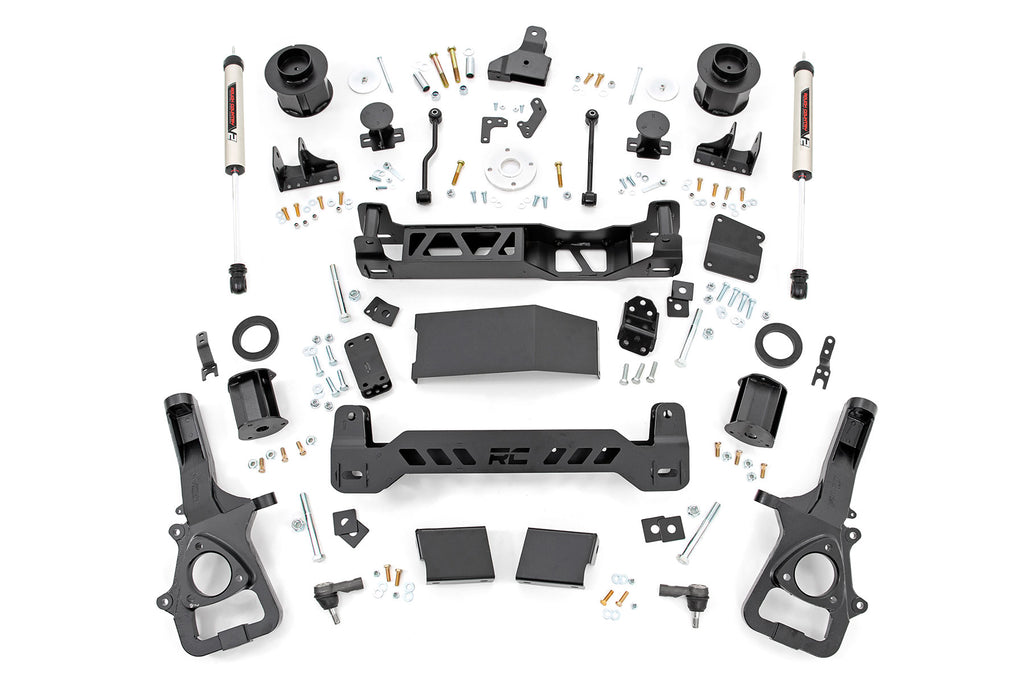 The 6 Inch Lift Kit | V2 | Ram 1500 4WD (2019-2023) is displayed on a white surface, featuring black crossmembers, heavy-duty knuckles, shocks, strut spacers, bolts, brackets, and hardware in a symmetrical top-down layout.