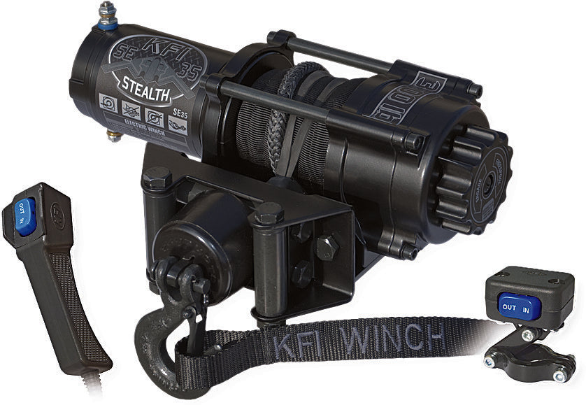 A black Stealth 3500 Winch with a coiled cable, hook, and KFI WINCH strap is mounted on a base. Nearby are wireless and wired IN/OUT remotes.