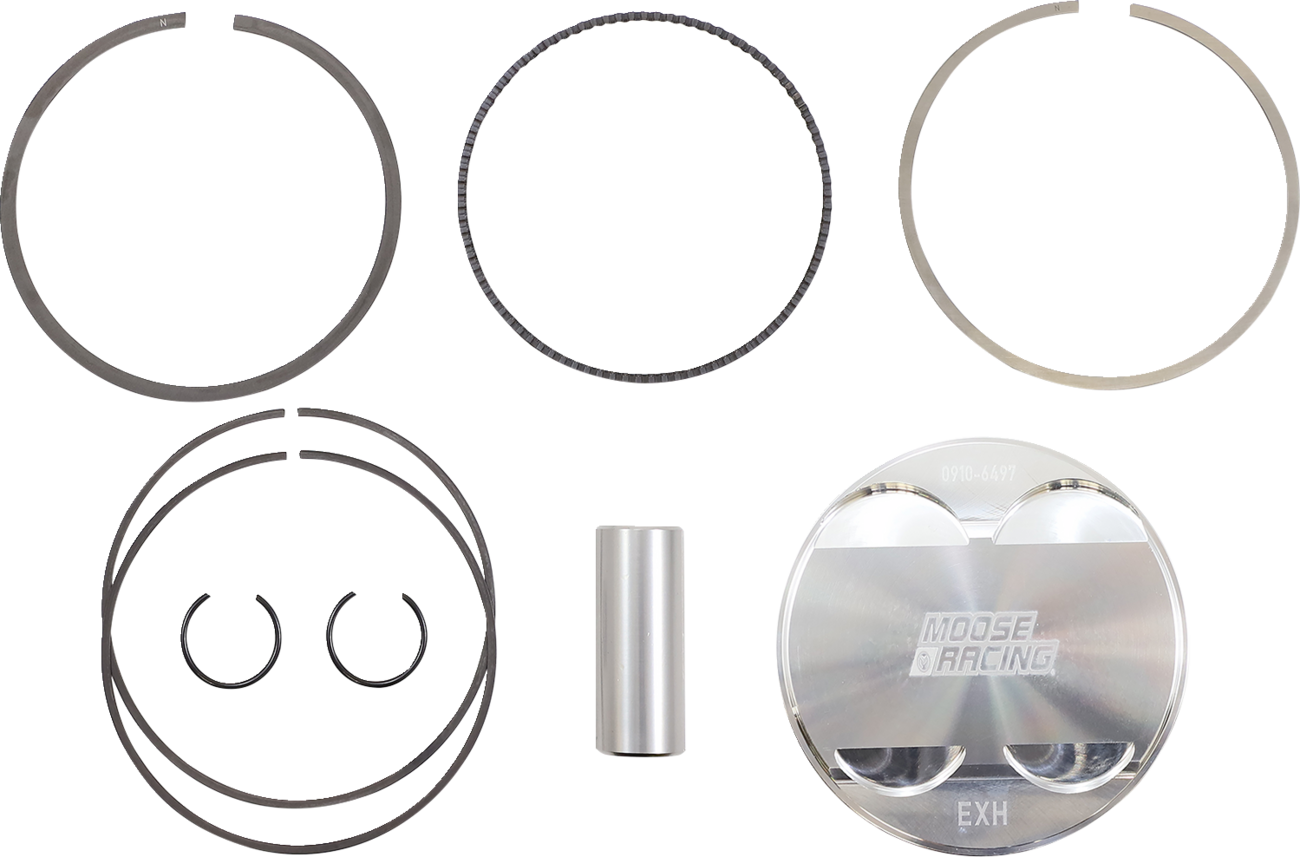 A metal piston kit is displayed on a white background, including a shiny piston marked MOOSE RACING EXH, rings, a cylinder pin, and two circlips. All components are arranged neatly in a flat lay.