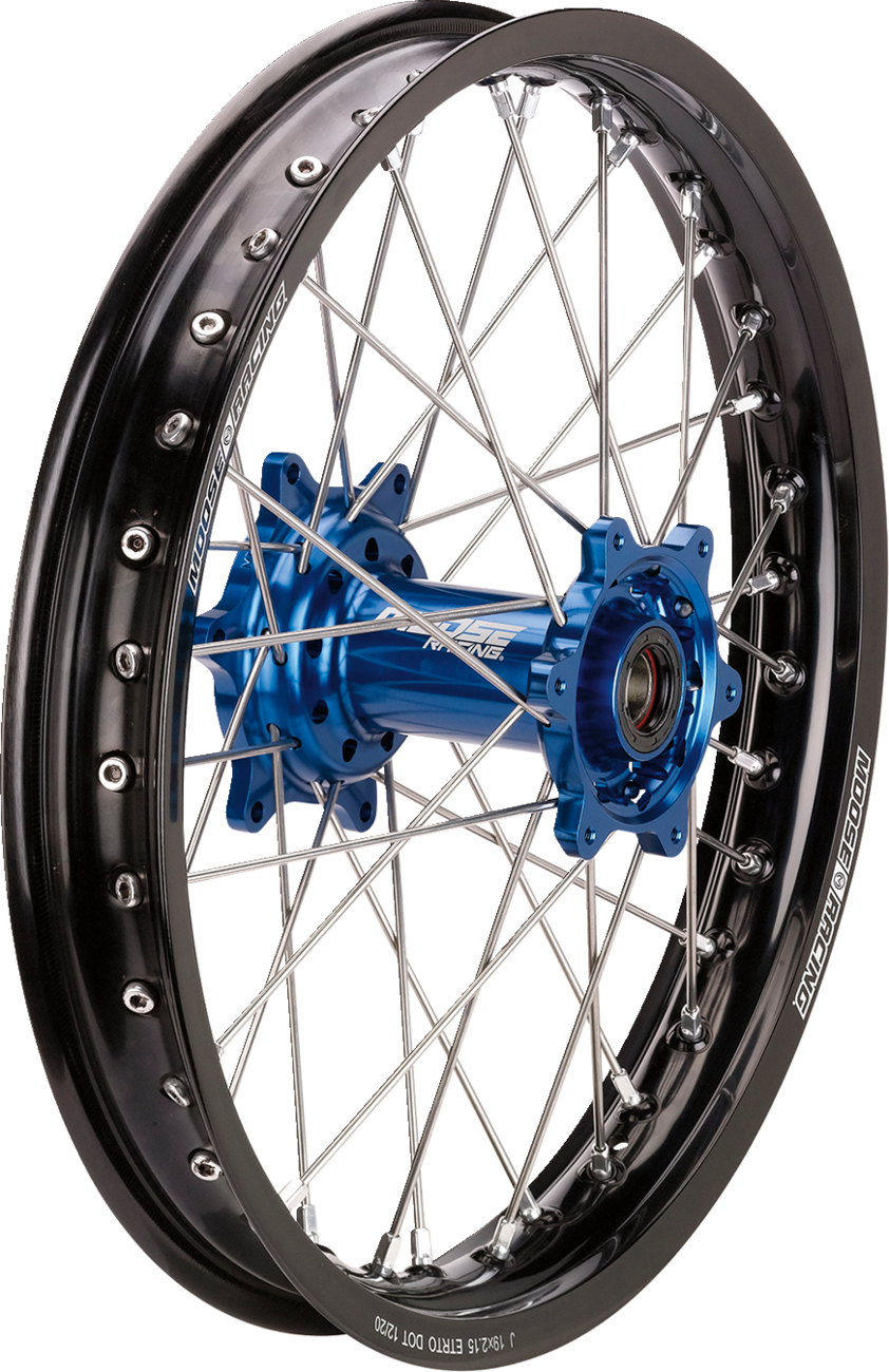 A black alloy motorcycle wheel rim with silver spokes radiating from a metallic blue hub, featuring printed text “1.85X21” and “HUB BY HINSON RACING” on the rim. The background is white with no other visible objects.