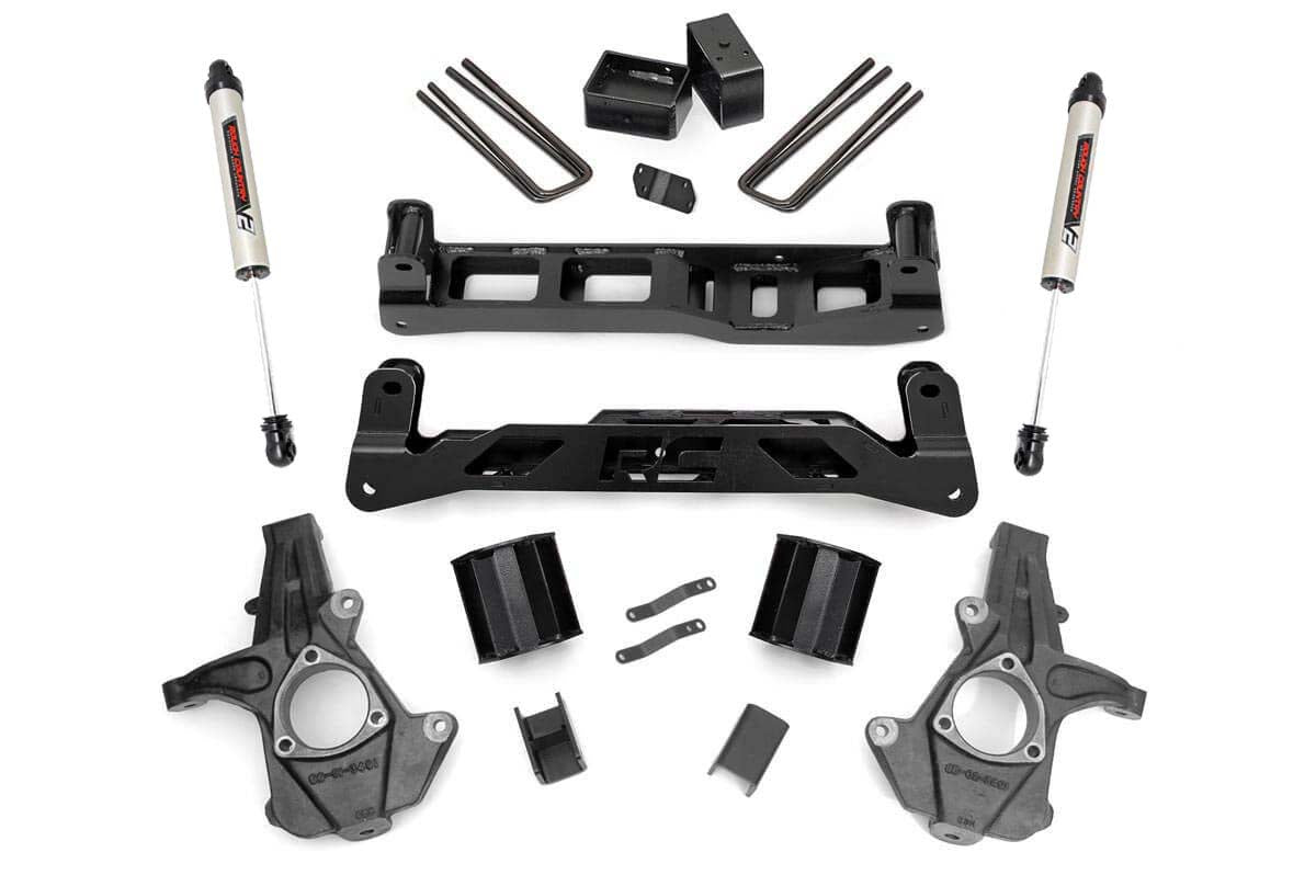 The 5 Inch Lift Kit | Alum/Stamp Steel | V2 for Chevy/GMC 1500 (14-18) is displayed on a white background, featuring black metal and silver components such as shock absorbers, lift blocks, U-bolts, control arms, spindles, brackets, and hardware.