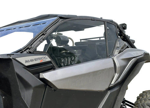 A close-up side view shows the Can Am X3 Venting Polycarbonate Upper Doors Kit (2017+) in black and gray, featuring doors with clear panels, part of the roll cage, and dashboard controls against a plain white background.