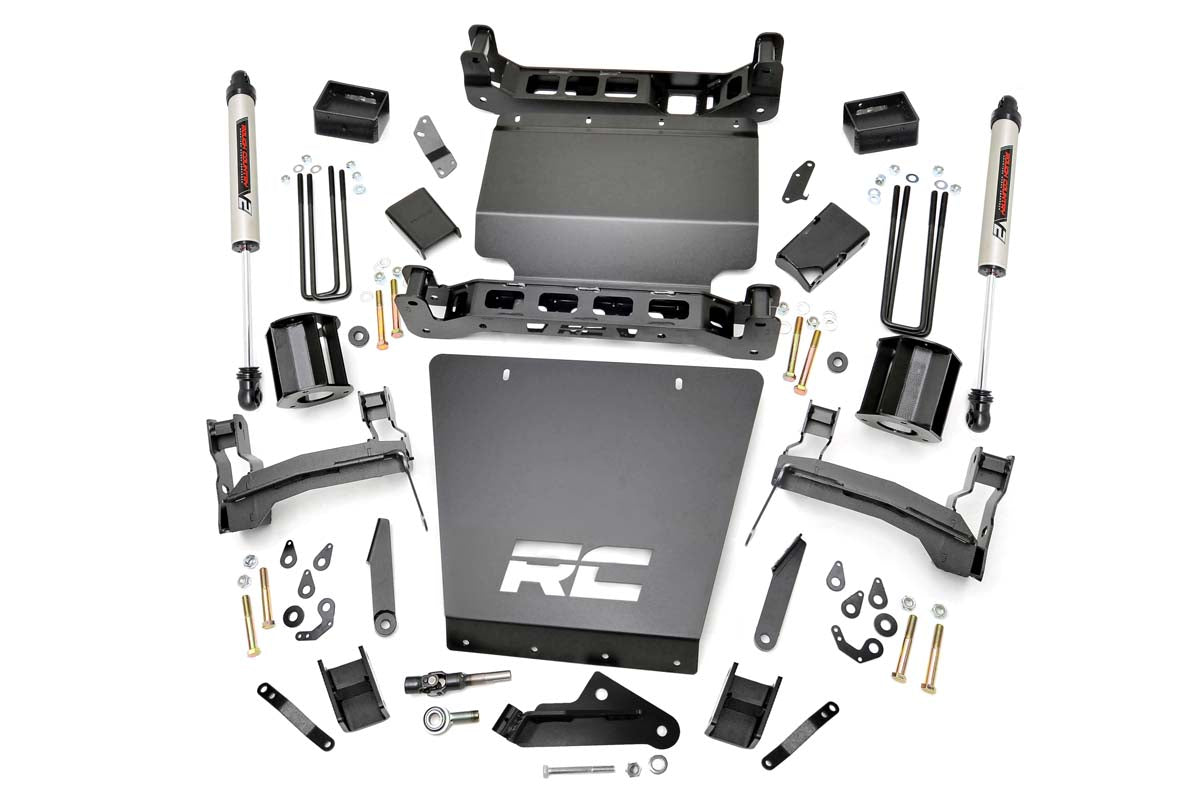 A 5 Inch Lift Kit for Chevy/GMC 1500 (14-18) with black brackets, V2 shocks, RC skid plates, spacers, U-bolts, bolts, nuts, washers, and hardware is laid out on a white surface.