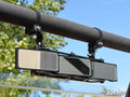 The 3 Panel Rear View Mirror with 1.75 Clamps is mounted on a horizontal roll bar with two adjustable brackets. Trees and a clear blue sky can be seen in the background, and the SuperATV logo appears in the bottom right corner.