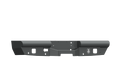 The 2015-2019 Chevy 2500 Vaquero Rear Non-Winch Bumper in texture black features angular corners, mounting holes, accessory cutouts, a welded logo on the right, and a rugged design for enhanced protection.