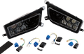 Two black automotive headlight assemblies with clear lenses are shown side by side. Below them are wiring harnesses, blue and black electrical connectors, and a strip of adhesive foam, all laid out on a white background.