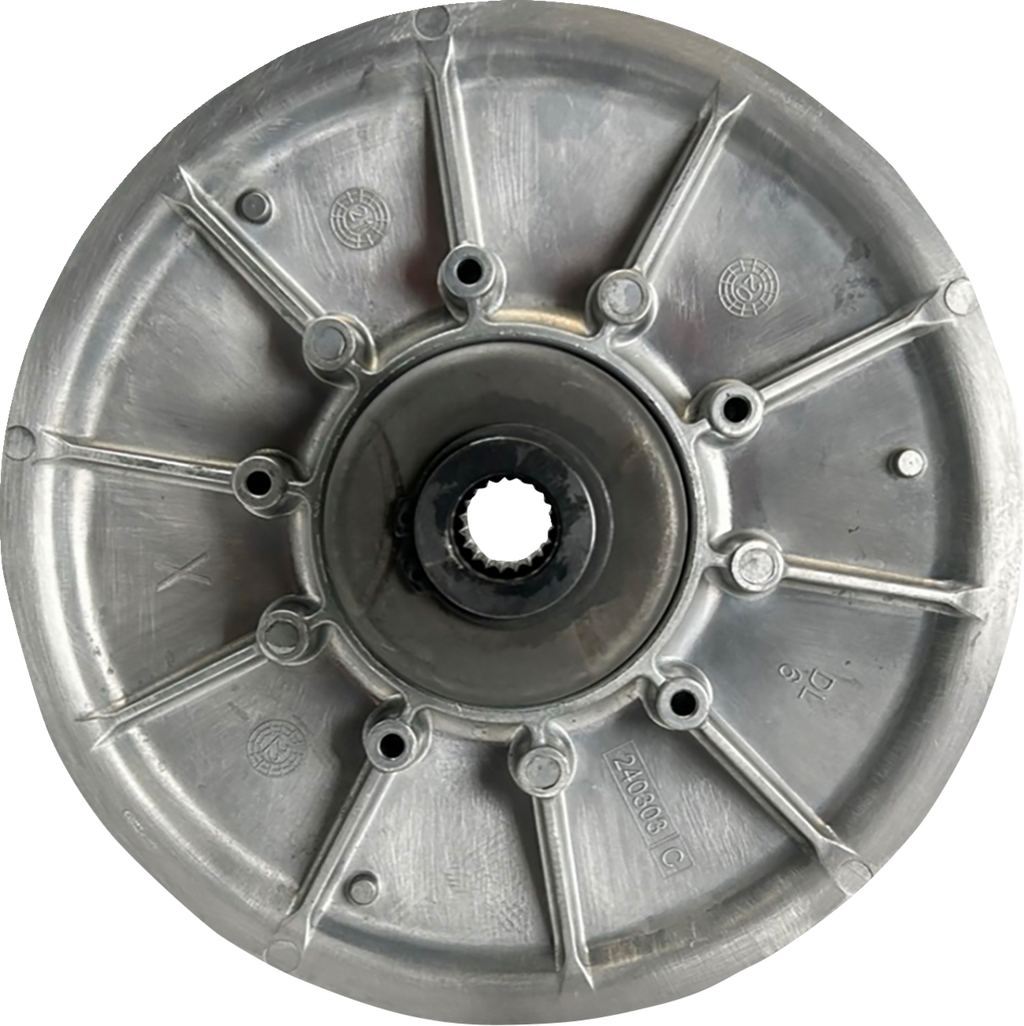 A metallic circular mechanical component with radial spokes, a central hole containing gear-like teeth, and several smaller holes around the center. The surface has numbers, letters, and embossed markings, suggesting it is a part of a machine or vehicle.