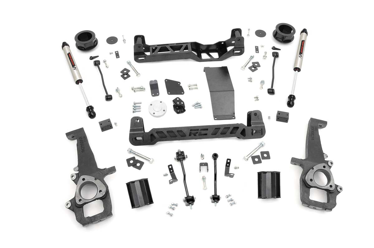 The 4 Inch Lift Kit | V2 for Ram 1500 4WD (2012-2018 & Classic) is displayed on a white background, featuring crossmembers, shock absorbers, spindles, spacers, brackets, bolts, washers, and hardware neatly organized in rows.