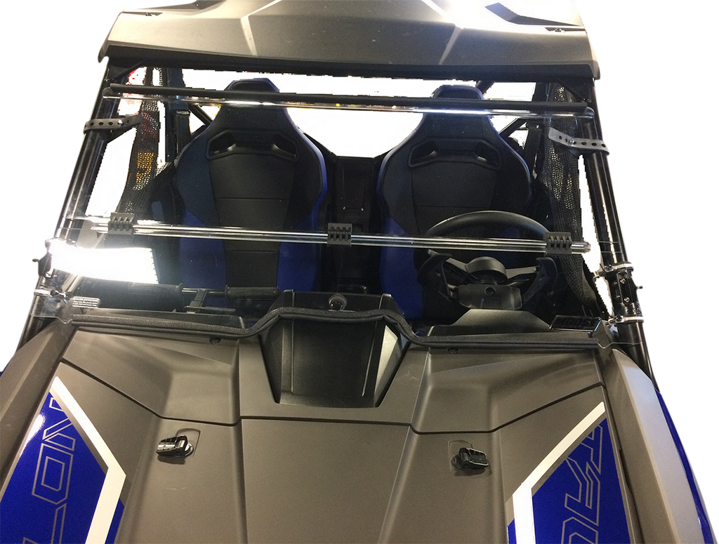 Close-up view of a vehicle’s front windshield and two blue bucket seats inside. The steering wheel is on the right, and the windshield has protective metal bars across it. The vehicle has a black and blue color scheme with angular design details.
