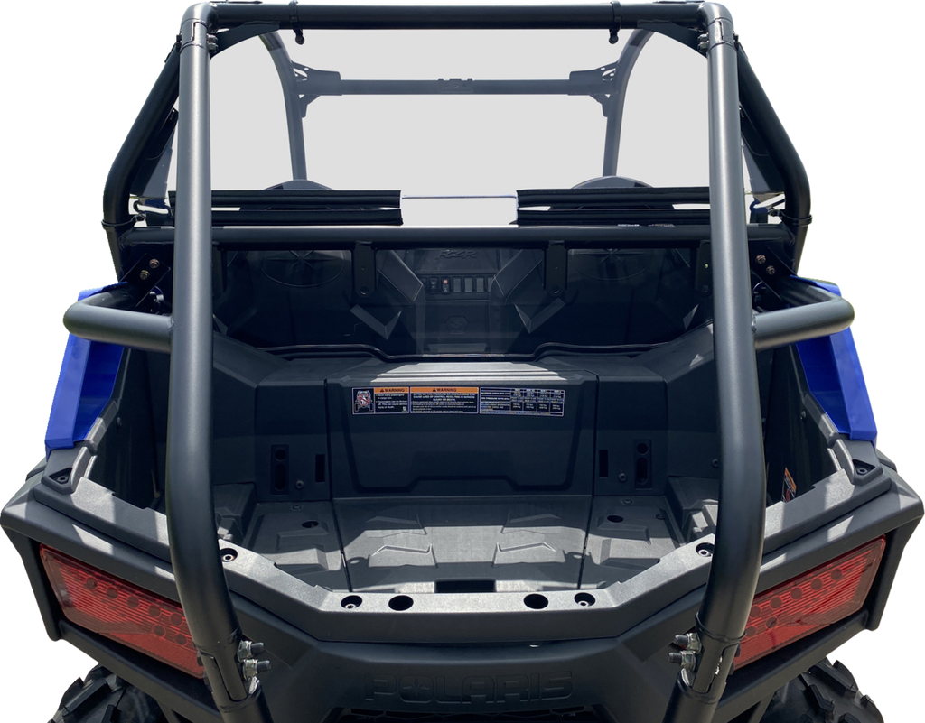 Rear view of an off-road utility vehicle with an empty cargo bed, tubular roll cage, two rear red tail lights, and a dashboard with visible warning stickers and controls. The vehicle features a sturdy, rugged design, and the image background is white.