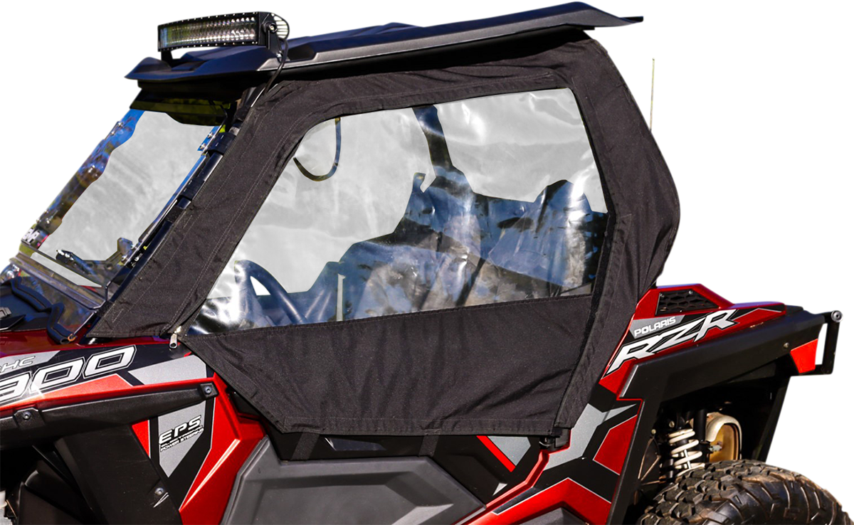 A close-up of a red Polaris RZR off-road vehicle with a black soft door and clear plastic window panel installed. The roof is black with a mounted LED light bar, and the image emphasizes the vehicle’s right side, showing rugged design details.