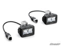 Two 3 x 1.5 Single-Row LED Cube Lights, each with metal mounting brackets and cables ending in gray connectors, are shown on a white background. SuperATV appears in the bottom right corner.