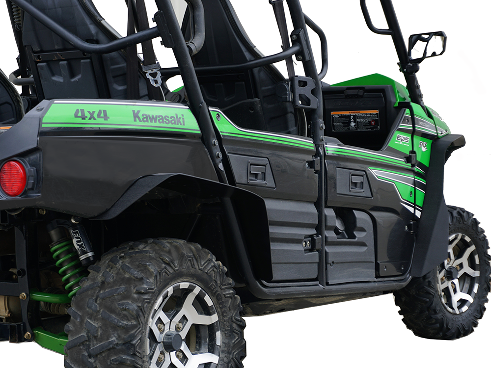 A close-up, angled view of Kawasaki Teryx-4 Over Fenders (Set 4) 2016+ installed on a green and black 4x4 off-road vehicle, featuring rugged tires, side doors, shock absorbers, seating area, and bold side stripes with branding.