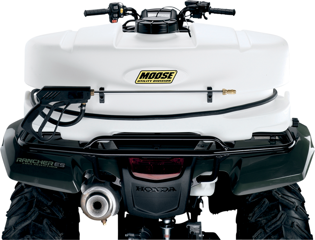Close-up of the rear of a Honda ATV with a large white Moose Utility Division sprayer tank mounted on the back. The tank features a hose and sprayer wand secured to it, and Rancher ES is labeled on the ATV’s side. The image emphasizes utility equipment.