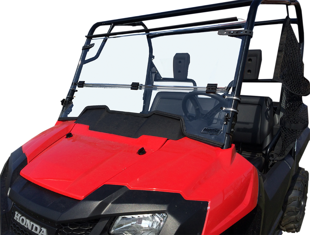 A red Honda utility vehicle with a clear polycarbonate windshield, black frame, and side nets. The windshield is split horizontally and attached with metal brackets to the frame. The vehicle has two visible seats and is photographed against a plain white 