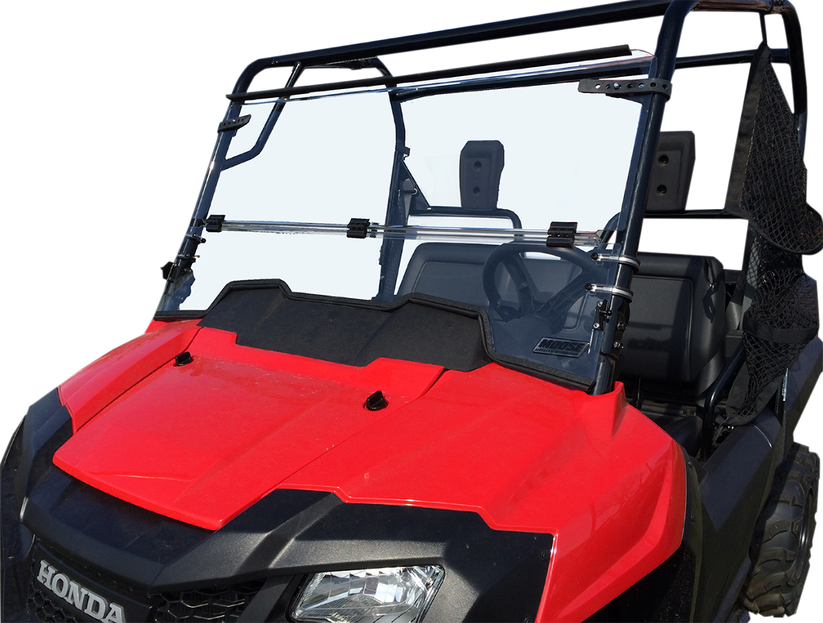 A red Honda utility vehicle with a clear polycarbonate windshield, black frame, and side nets. The windshield is split horizontally and attached with metal brackets to the frame. The vehicle has two visible seats and is photographed against a plain white 