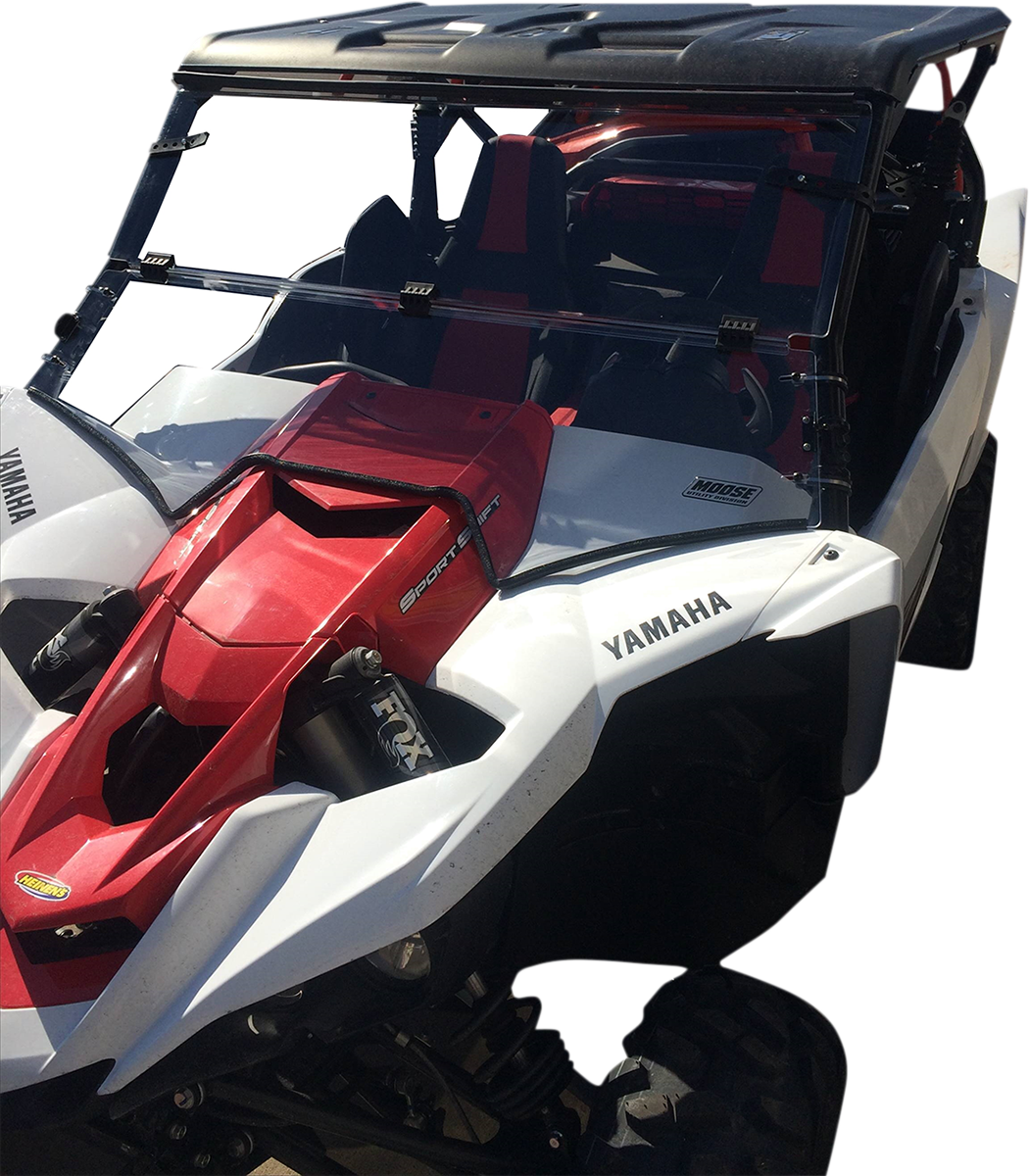 A white and red Yamaha off-road side-by-side vehicle with a roof, open sides, heavy-duty tires, FOX shocks, and bold Yamaha logos on the hood and fenders; two bucket seats are visible through the windshield.