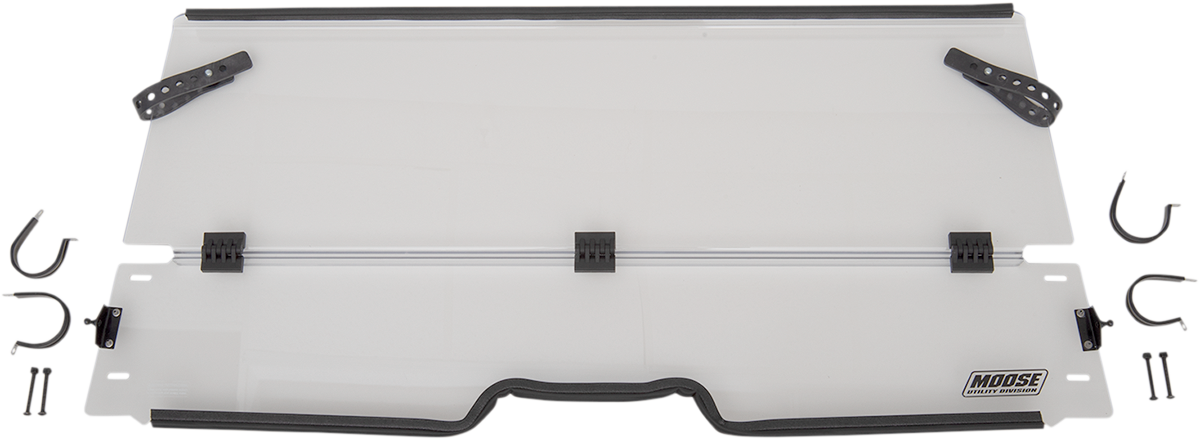 A clear, rectangular windshield with black mounting brackets and hardware pieces arranged around it. The windshield has a slight notch at the lower center and a Moose Utility Division logo in the bottom right corner. Two black adjustable arms are attached
