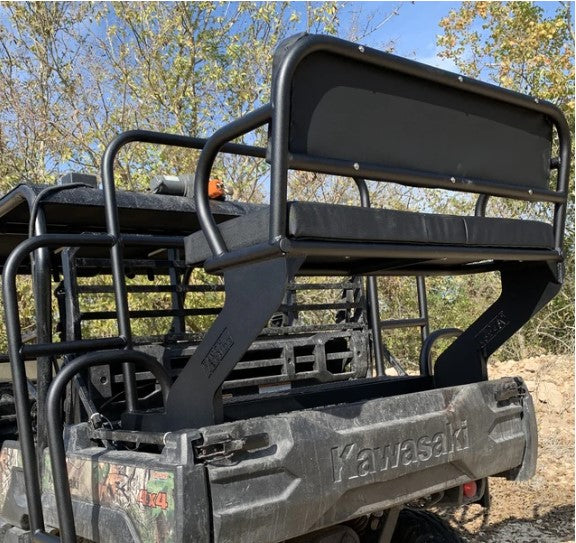 A Kawasaki Mule Pro Fxt with a black Aluminum High Seat, featuring metal frame supports mounted in the truck bed. The rugged 4x4 utility vehicle is shown outdoors with trees and a bright sky in the background.