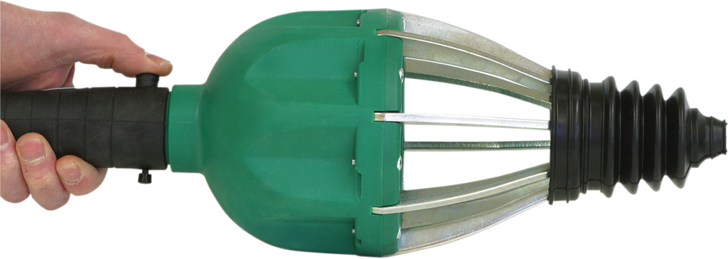 A hand grips the black handle of a green and silver mechanical tool with metal prongs and a black, ridged rubber cone at the end. The tool appears to be a pipe or drain cleaning device, held horizontally against a white background.