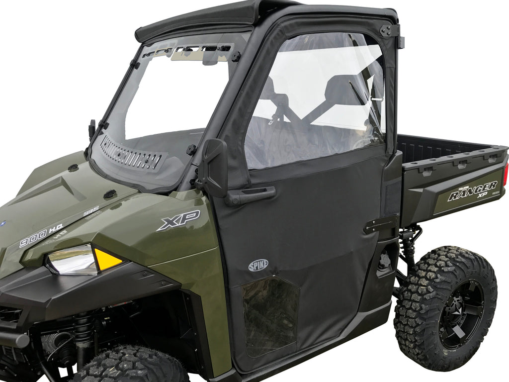 A Polaris Ranger XP with rugged tires, black Spike Pro-Fit doors, a clear window, and black roof. The side features XP and Ranger logos. Its cargo bed and design make it ideal for off-road terrain.