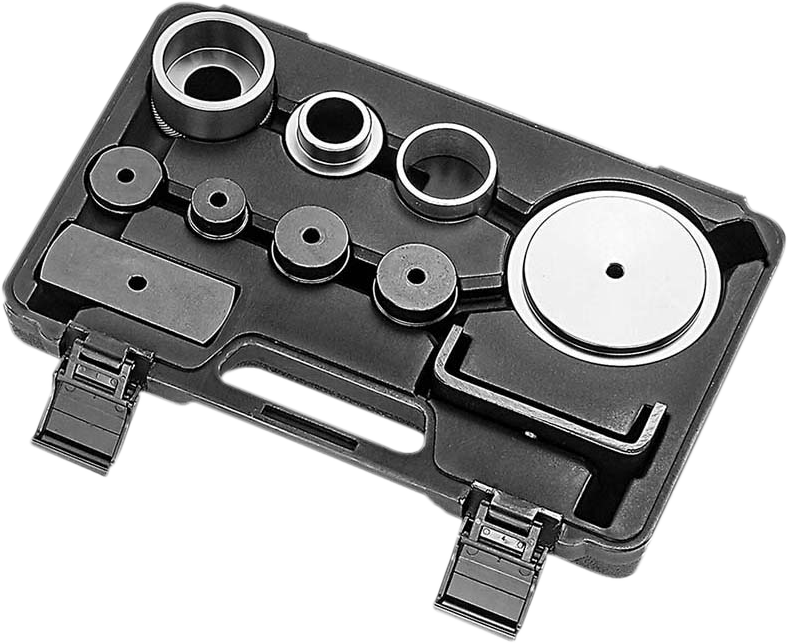 A black plastic tool case containing various circular metal discs and rings of different sizes, arranged neatly in molded slots, with two latches in front and a molded handle in the center. The pieces appear to be part of an automotive or mechanical tool 