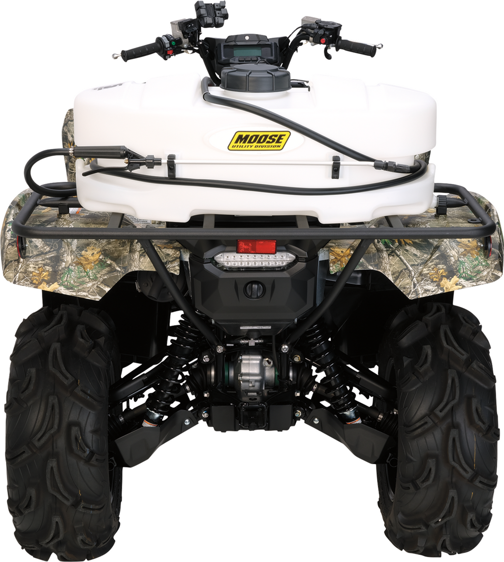 Rear view of an ATV with large, rugged tires. A white tank labeled Moose is mounted on the rear cargo rack. The ATV features a camouflage pattern, exposed suspension, handlebars, and a coiled hose attached to the tank.