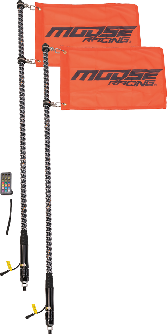 Two LED whip lights with orange Moose Racing flags attached. Each whip features a black base, a spiral LED design, and an attached remote control for color and mode adjustments. The flags display the brand logo in black text.
