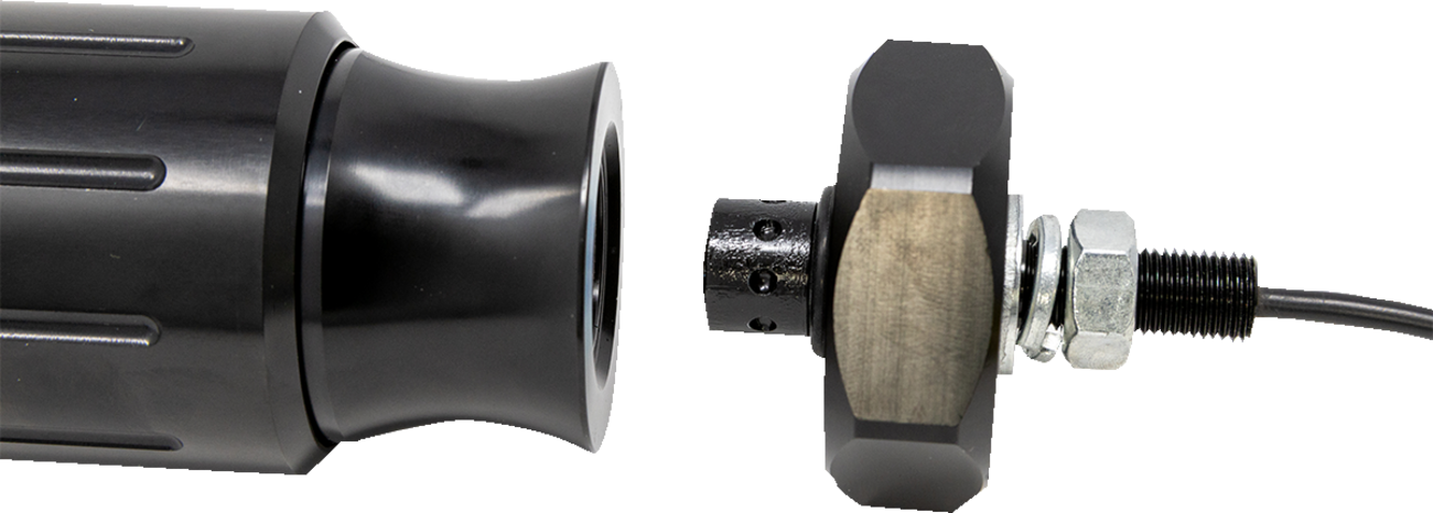 Close-up of a black cylindrical metal device with a flared end on the left and a round, knurled metal component connected to a cable on the right. Both parts are aligned but separated, showing threaded metal and a nut.