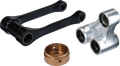 Three mechanical parts: a black U-shaped linkage with bearing holes at each end, a silver triple-connector component with three circular openings containing bearings, and a round bronze-colored cap with a central hole and side groove. All parts are metall