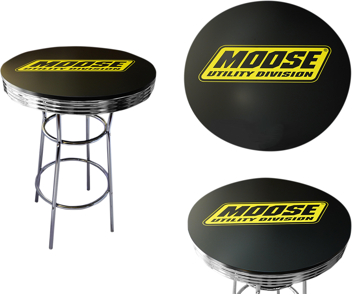 A round black bar table with a chrome base and three circular footrests. The tabletop displays a yellow and black MOOSE UTILITY DIVISION logo. Two close-up views of the tabletop, showing the logo clearly, appear on the right.