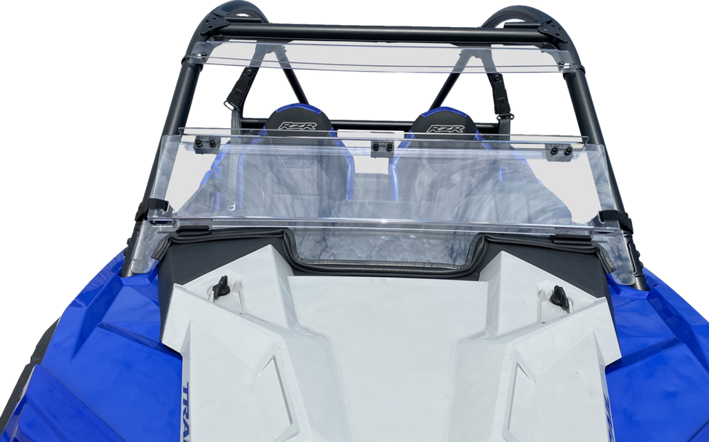 A close-up view of the front interior of a blue and white off-road vehicle, featuring two black seats with RZR logos and a transparent windshield attached to a black roll cage. The vehicles angular hood and side panels are also visible.